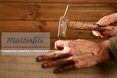 Carpenter hands with hammer wood and nail on wooden background
