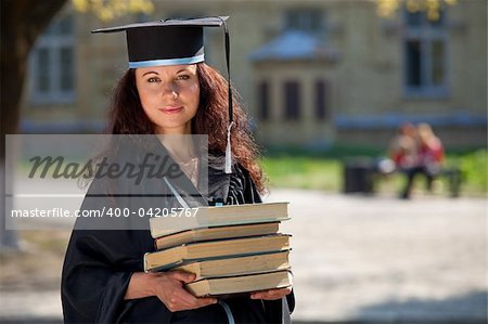 Graduate of university with books near library