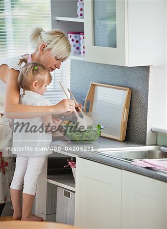 Concentrated mother and child cooking in kitchen