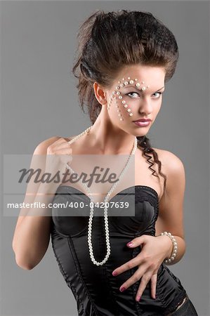 young and sexy woman in black corset with pearl necklace and perfect creative make up