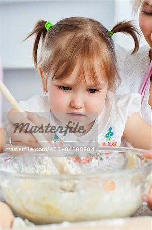 Relaxed woman baking cookies with her daughter in kitchen