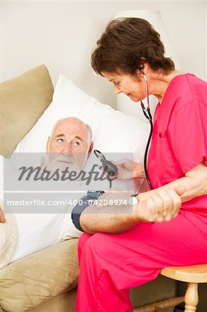 Home health nurse taking an elderly patient's blood pressure.  Vertical view.