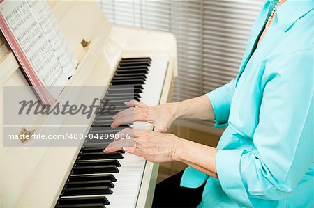 Closeup of a pianists hands as she plays a hymn at church.  Shallow depth of field.