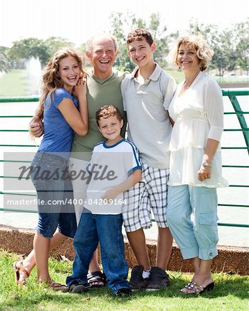 Happy family posing infront of the lake on a sunny day