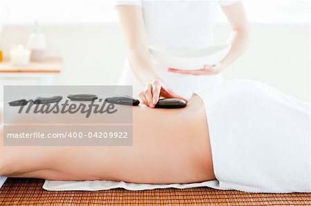 Close-up of a caucasian man having hot stone on his back in a health spa