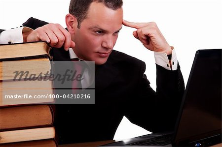 businessman on desk with books, looking at the computer, isolated on white background, studio shot.