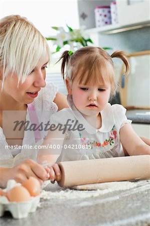 Attentive young mother baking with her daughter in the kitchen