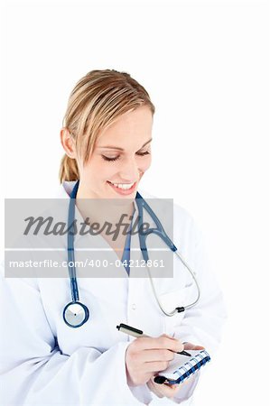 Concentrated female doctor taking notes on her notepad against a white background