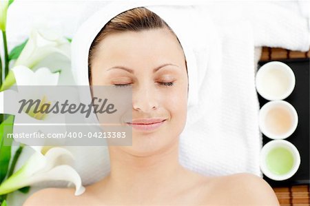 Happy young woman resting on a massage table in a spa center