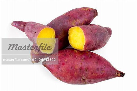 Cooked whole and halved sweet potatoes on white.