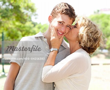 Portrait of a happy old woman kissing her adorable grandson