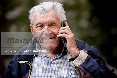 A portrait of a senior using a cell phone outdoors