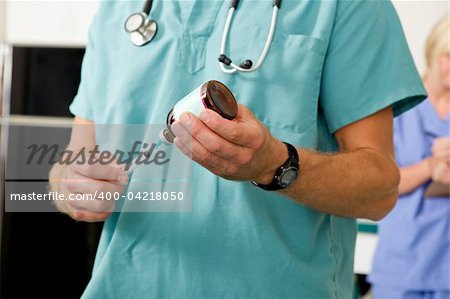 A doctor or vet drawing medicine out of a bottle