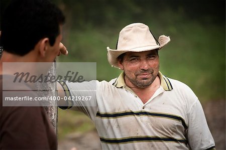 Handsome male ranch hands on dairy farm in Costa Rica