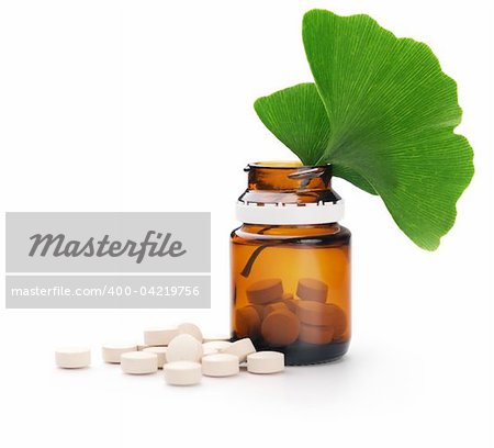 Herbal medicine. Ginkgo leaves and tablets n a bottle. Isolated over white background