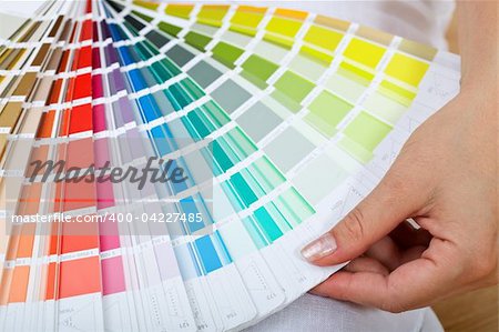 Picking the right paint - woman hand with color sample chart