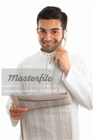 An ethnic italian / arab mixed race businessmanwearing traditional middle eastern clothing.  He is on the telephone and holding a newspaper at finance section.  White background.