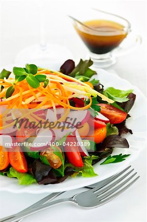 Plate of healthy green garden salad with fresh vegetables served with balsamic dressing