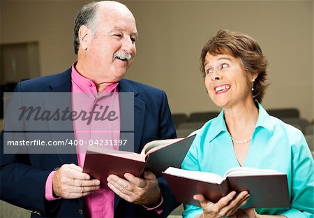 Husband and wife in church, singing hymns.