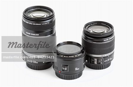 A set of three lenses for DSLR camera on a white background