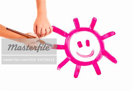 Child hands painting a happy sun, isolated on white