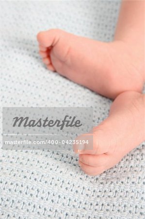 Baby feet on a blue woolen blanket