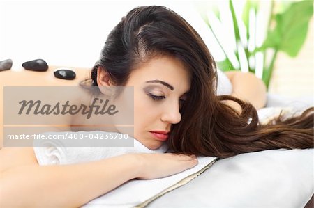 Attractive woman getting a stone massage in a spa