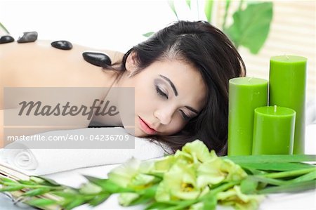 Attractive woman getting a stone massage in a spa