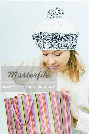 girl in winter hat looks in a package