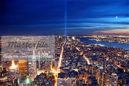 Remember September 11. New York City Manhattan panorama view at night with office building skyscrapers skyline illuminated over Hudson River and two light beam in memory of September 11.