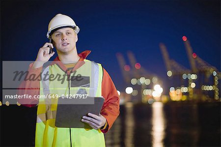 Worker talking on cell phone in shipyard