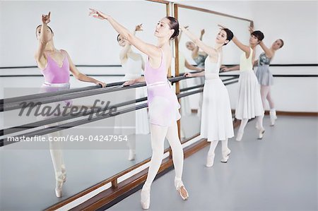 Ballet dancers posing at barre