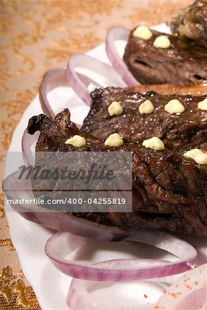 Fried ribs served with the rings of onion