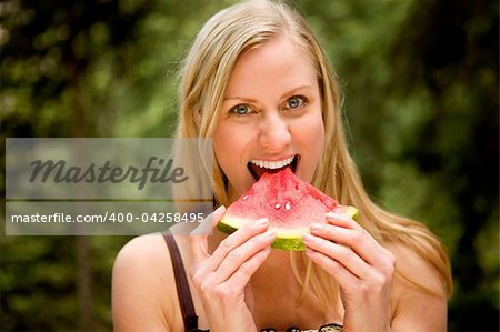 A happy woman eating a fresh watermelon