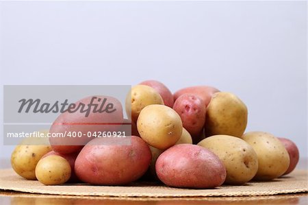 Red and white organic potatoes on a straw mat. Shallow dof