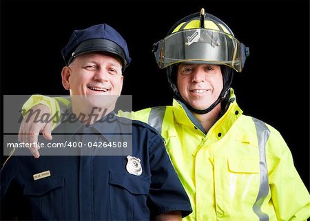 Portrait of happy, smiling police officer and fire fighter on black background.