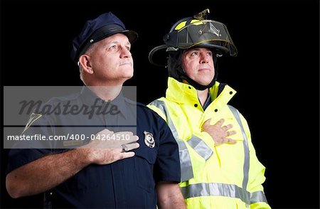 Police officer and fire fighter with their hands over their hearts as they say the Pledge of Allegiance.