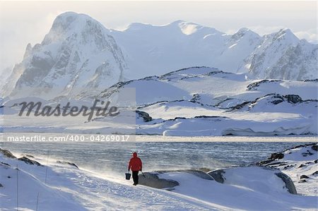 Man goes fishing in a snowstorm. Antarctica