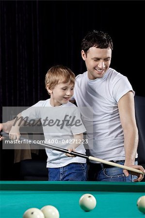 The young man with the son plays billiards