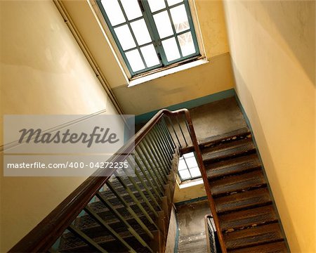 Looking down at an old wooden stairs at an abandoned building