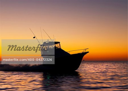 Fishing off the coast with a yellow and red sky in the background