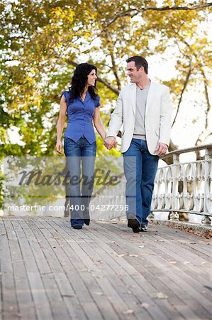 A couple walking on a bridge in a park