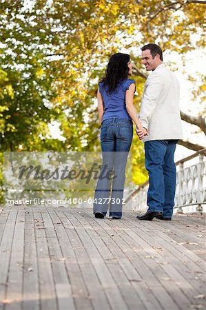 A happy engagement couple walking in the park on a beautiful day