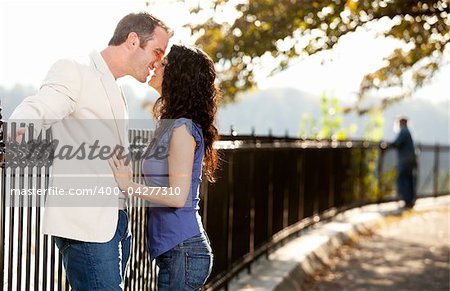 A happy couple in love kissing in the park