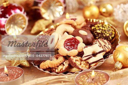 Detail of delicious Christmas cookies with candles in golden tone