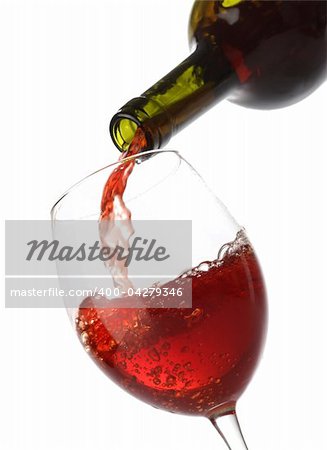 Pouring red wine into a glass isolated on white