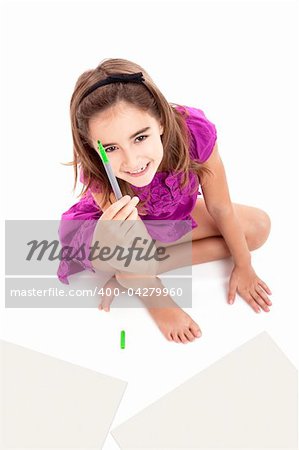 Girl sitting on floor and making drawings on paper