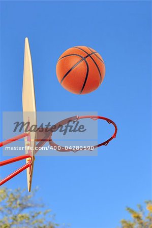 Basket hoop and basketball against blue sky