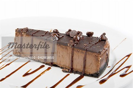 chocolate cake on a white plate drizzled with chocolate sauce