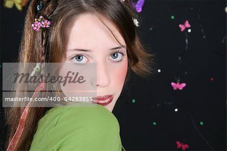 Teenage model with flowers and butterflies in her hair